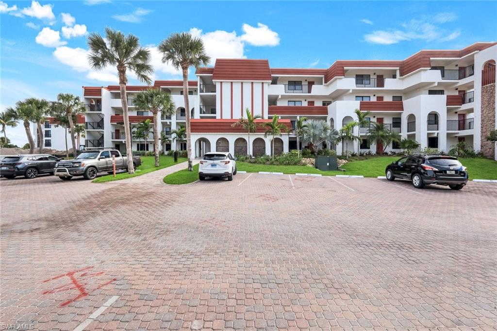 View of apartment building / complex with uncovered parking