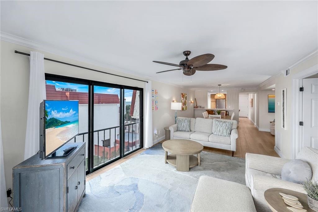 Living area featuring crown molding, ceiling fan, and wood finished floors
