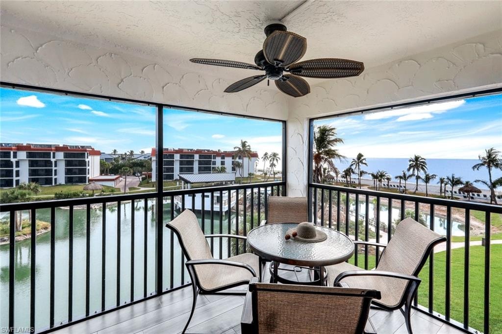 Balcony featuring a water view and ceiling fan