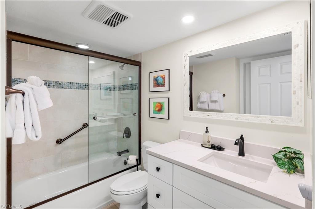 Full bathroom featuring bath / shower combo with glass door, vanity, and recessed lighting