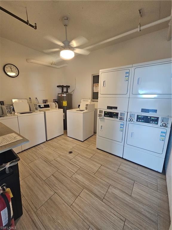 Shared laundry room featuring ceiling fan, washing machine and clothes dryer, and water heater