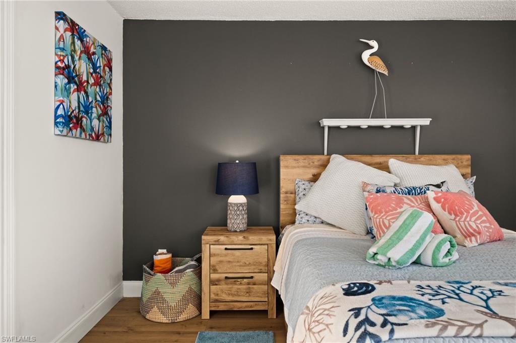 Bedroom with wood finished floors and baseboards