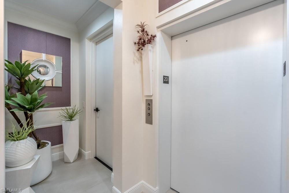 Hall featuring elevator and crown molding