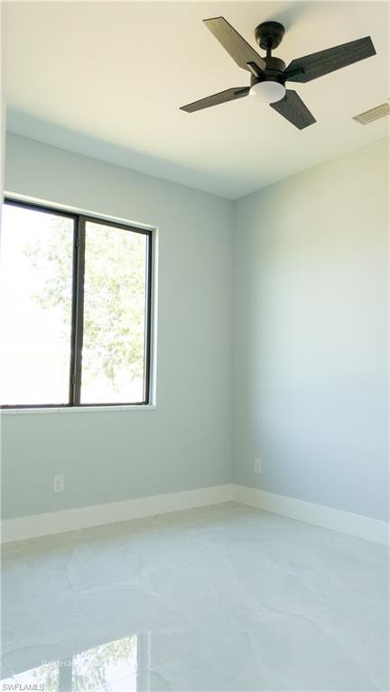 Unfurnished room with a ceiling fan and baseboards