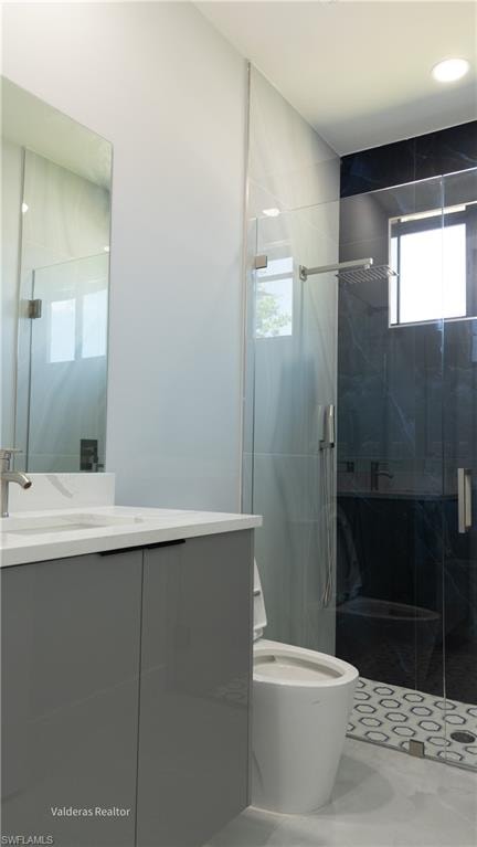 Full bathroom featuring vanity, a marble finish shower, and recessed lighting
