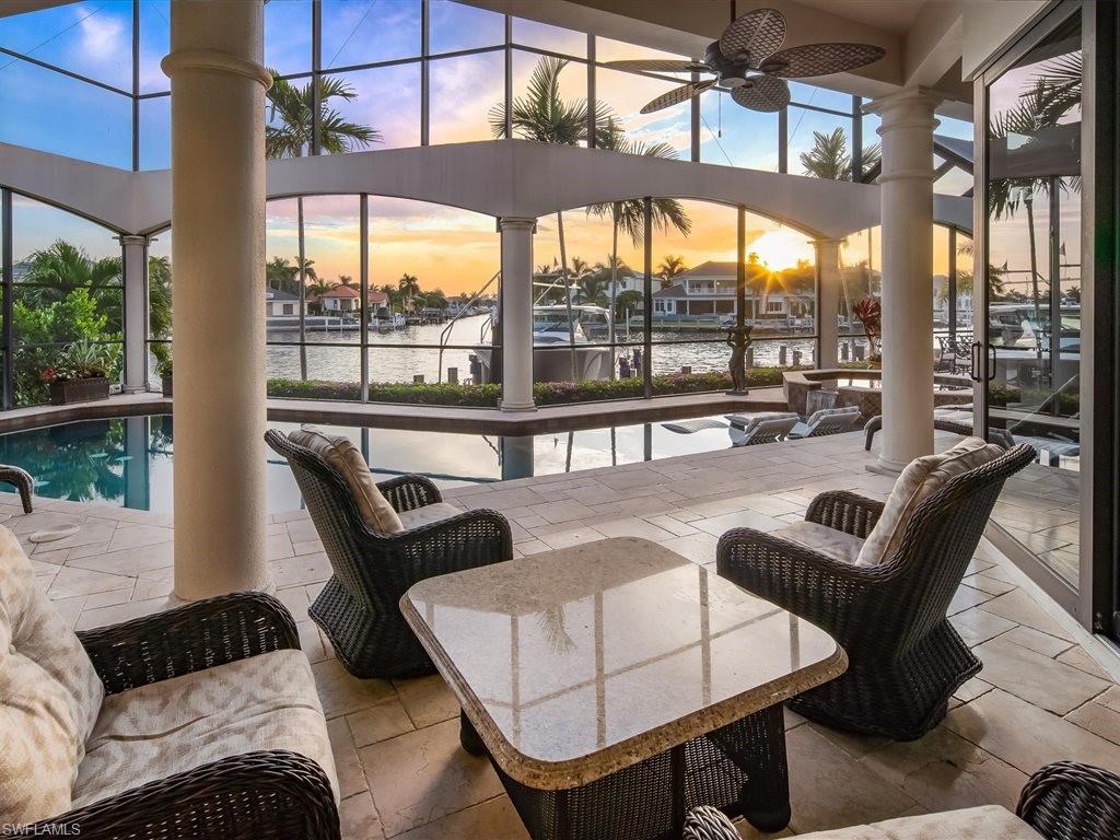 View of patio / terrace featuring ceiling fan, a water view, a sunroom, and a lanai