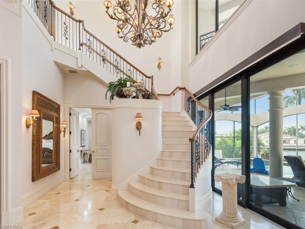 Stairway featuring a high ceiling and a chandelier
