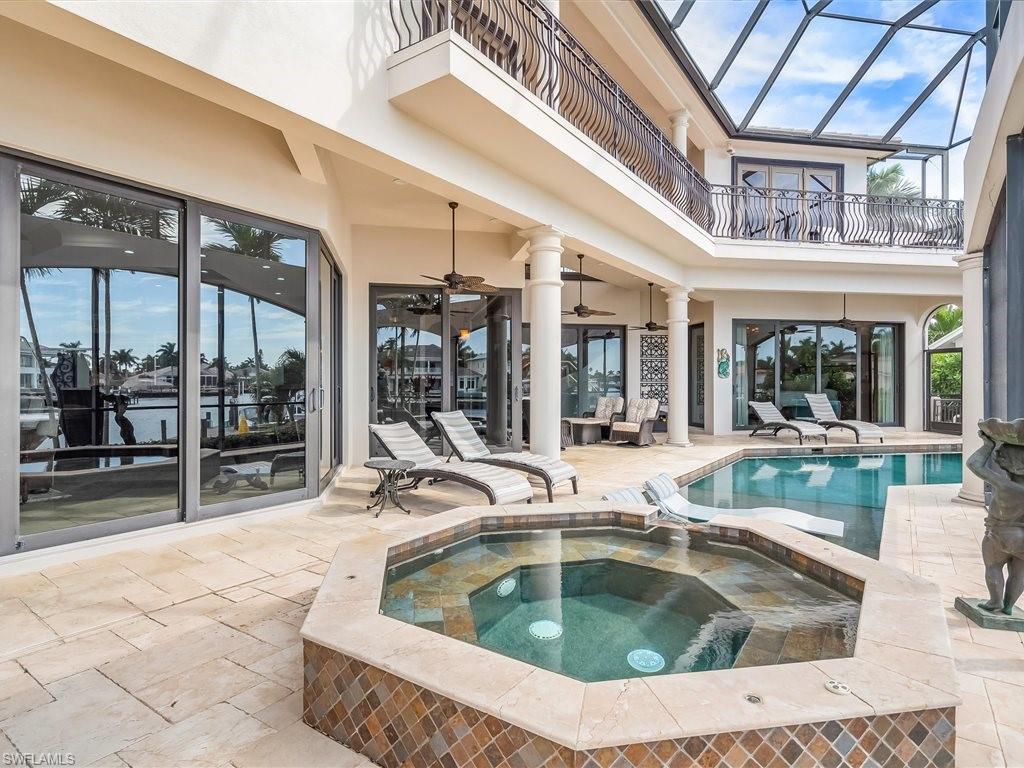 View of swimming pool with a balcony, a sunroom, a patio area, a pool with connected hot tub, and a lanai