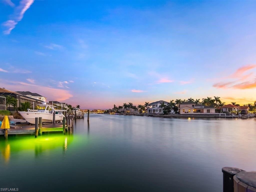 Dock area featuring boat lift, a water view, and a residential view