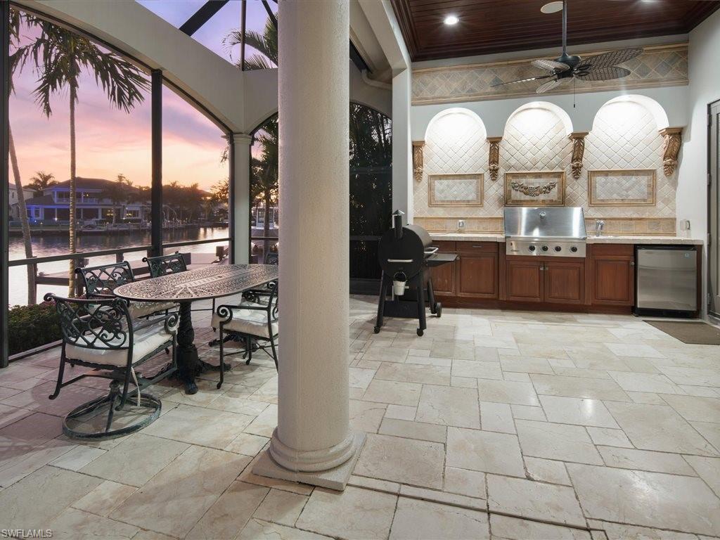 View of patio with a ceiling fan, area for grilling, a water view, and outdoor dining area