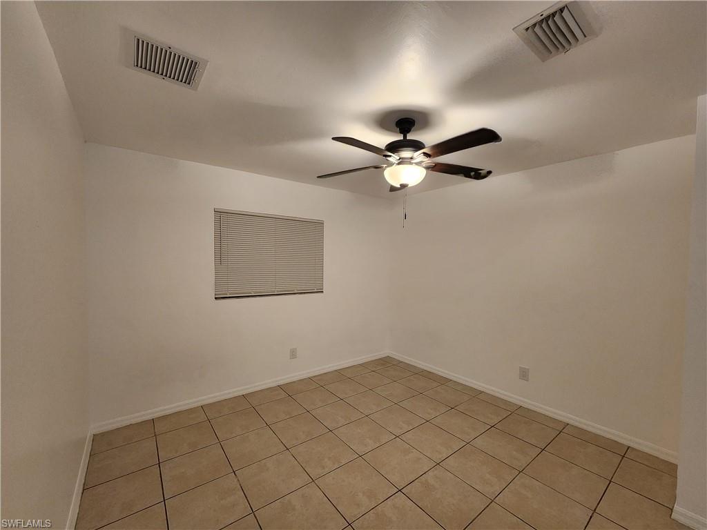 Unfurnished room with ceiling fan and light tile patterned floors