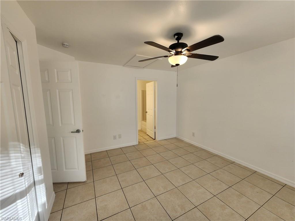Unfurnished bedroom featuring light tile patterned floors and a ceiling fan