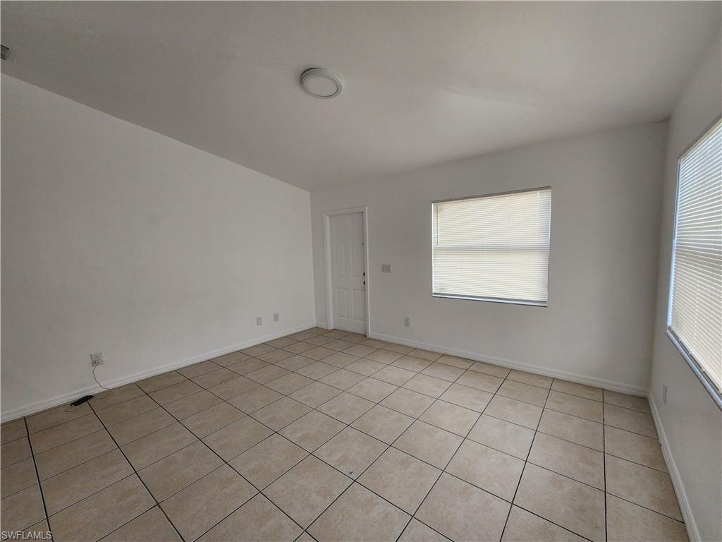 Spare room with baseboards and light tile patterned flooring