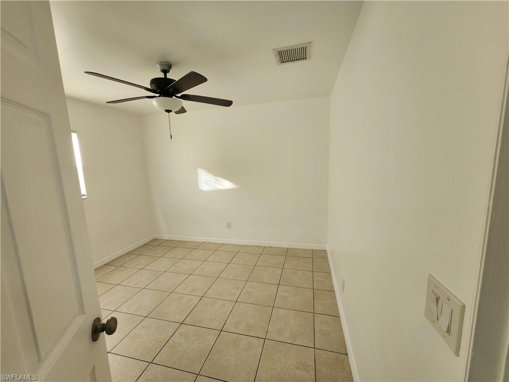 Unfurnished room featuring light tile patterned floors and a ceiling fan