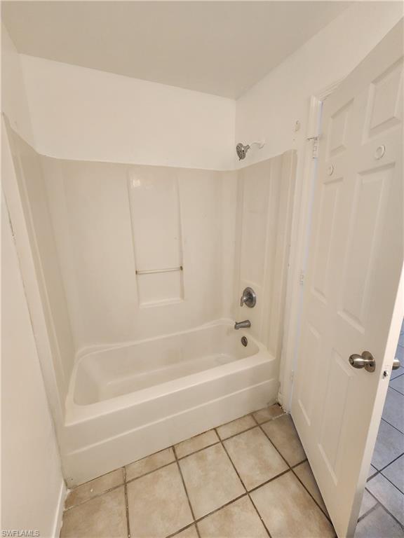 Bathroom featuring tile patterned floors and bathing tub / shower combination