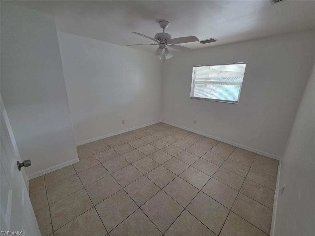 Unfurnished room with light tile patterned floors and ceiling fan