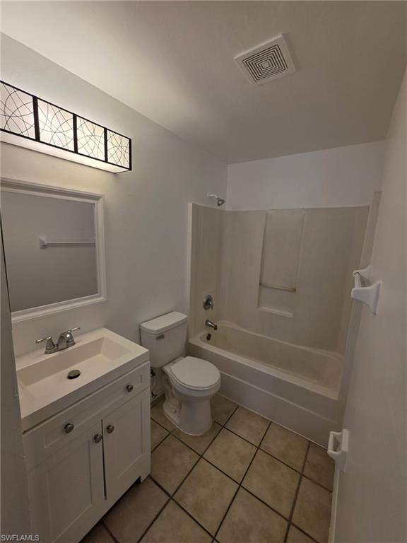 Full bath with vanity, shower / bathtub combination, and light tile patterned floors