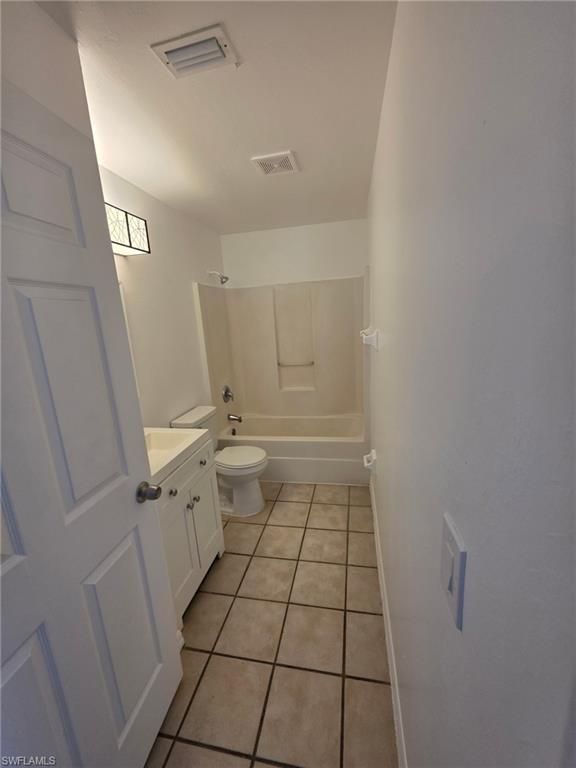 Bathroom featuring vanity, light tile patterned floors, and shower / washtub combination