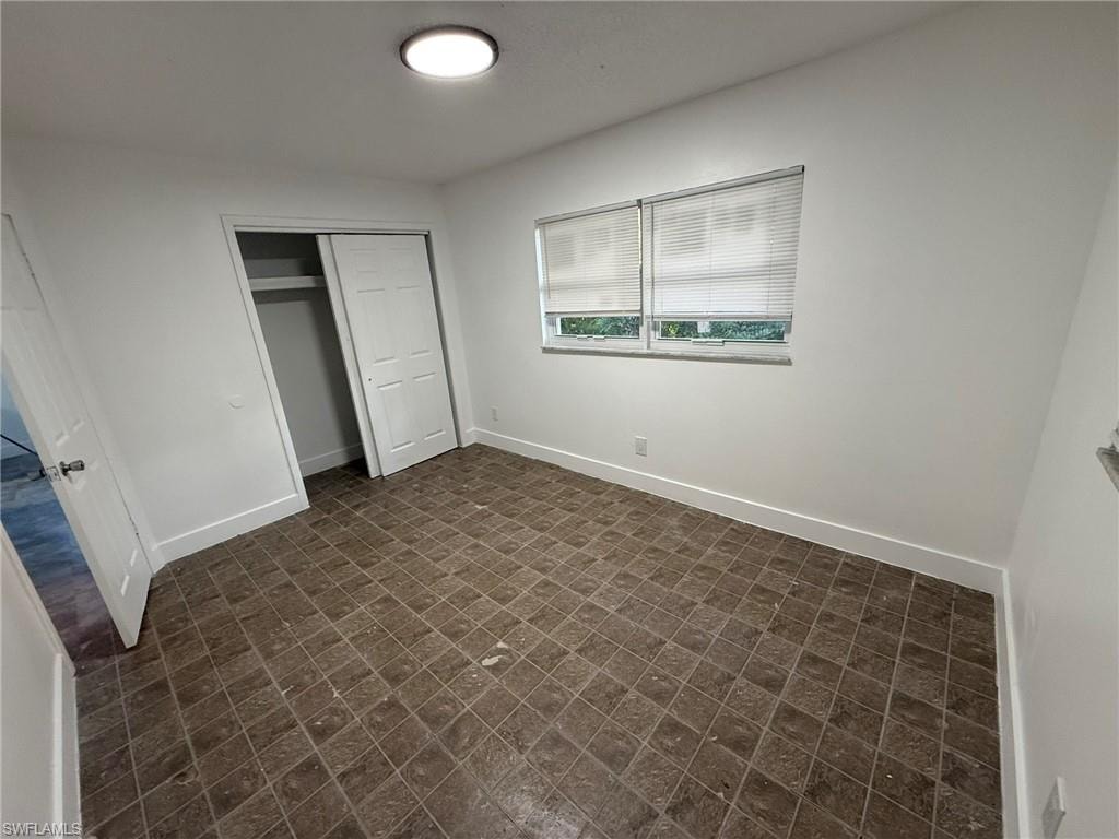 Unfurnished bedroom featuring baseboards and a closet