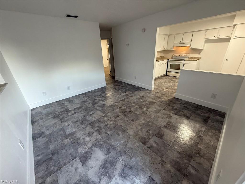 Unfurnished living room with baseboards