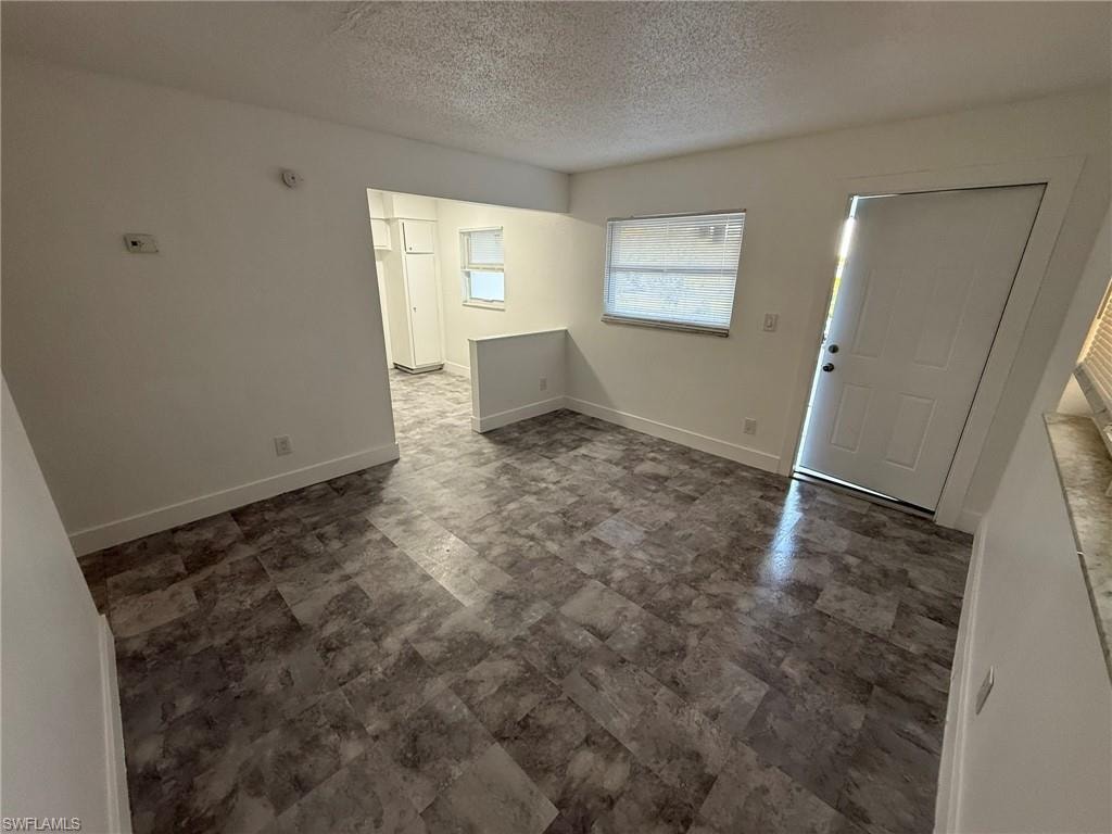 Entrance foyer featuring a textured ceiling and baseboards