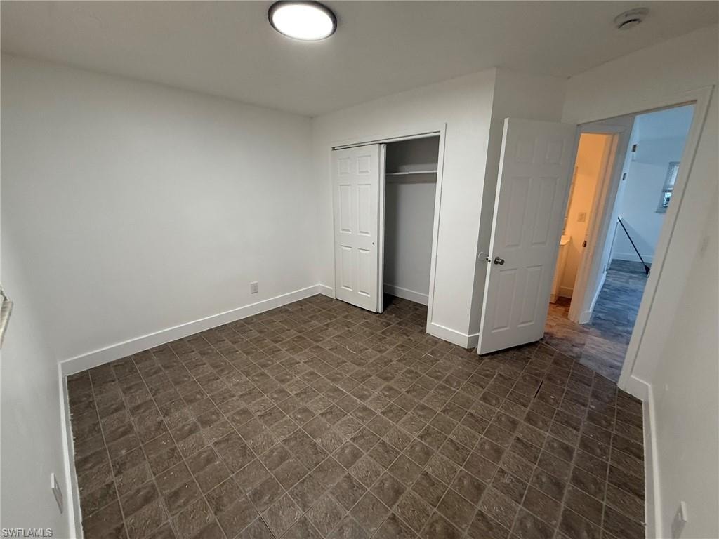 Unfurnished bedroom with a closet and baseboards