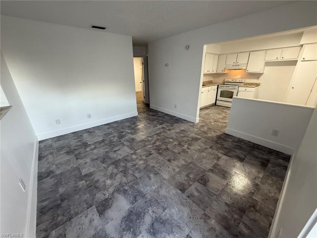 Unfurnished living room featuring baseboards