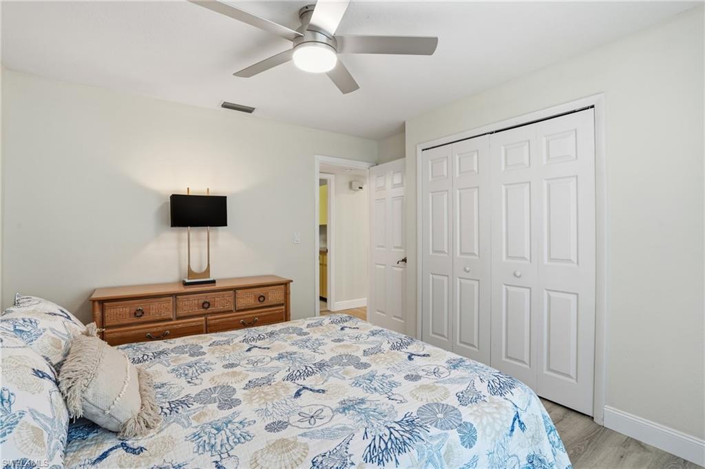 Bedroom with a closet, ceiling fan, and light wood-type flooring