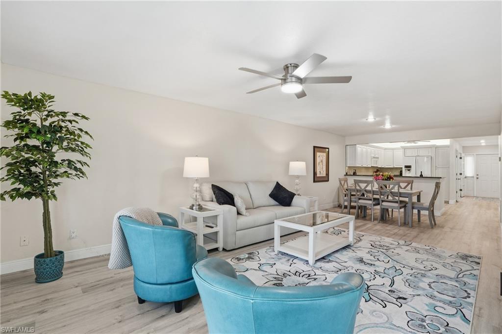 Living area with light wood-style floors and a ceiling fan