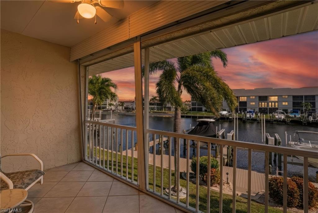 Balcony at dusk with a ceiling fan and a water view