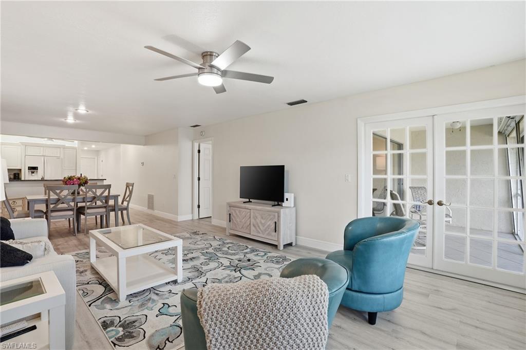 Living room featuring french doors, wood finished floors, and ceiling fan