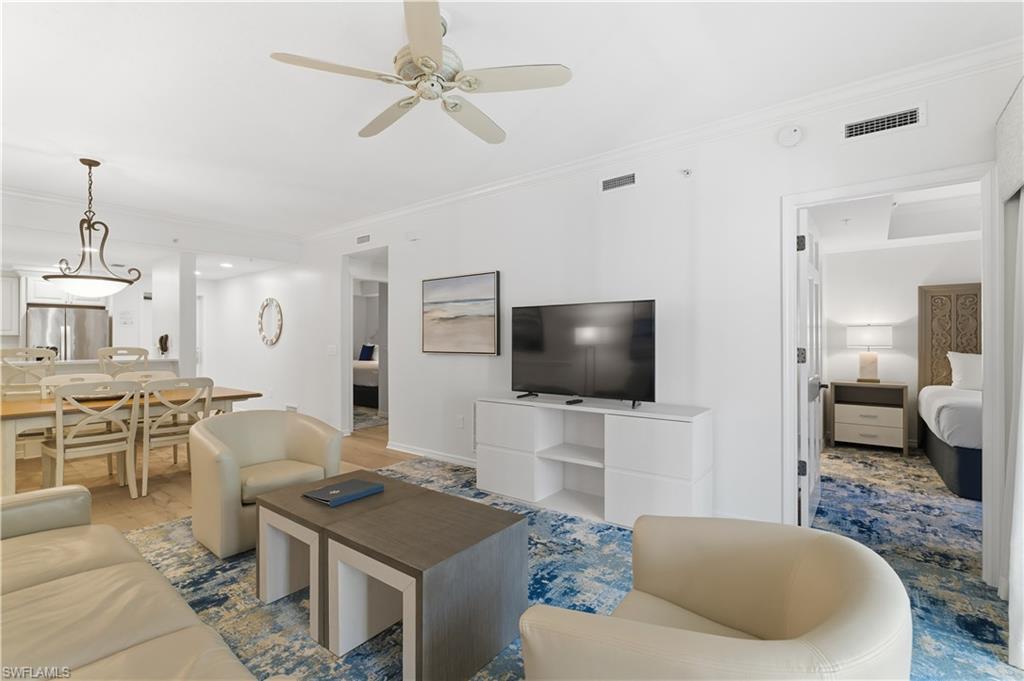 Living area with ornamental molding, a ceiling fan, and wood finished floors