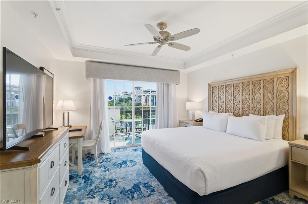 Bedroom featuring access to outside, a tray ceiling, ornamental molding, and ceiling fan