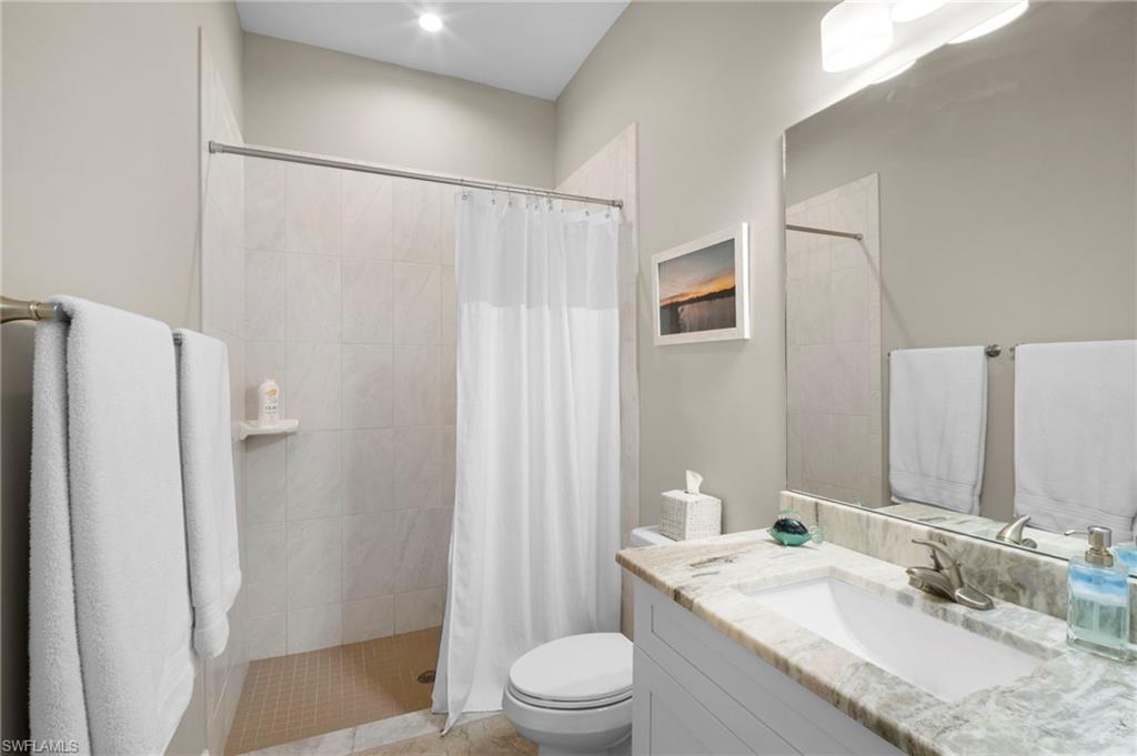 Full bath featuring vanity and tiled shower