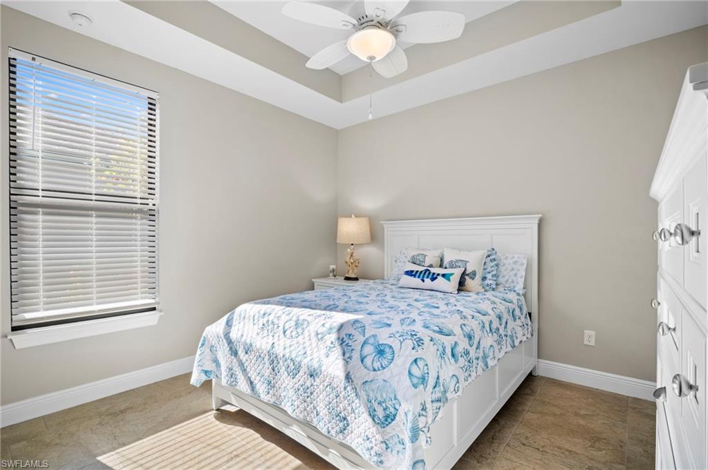 Bedroom featuring a tray ceiling and a ceiling fan