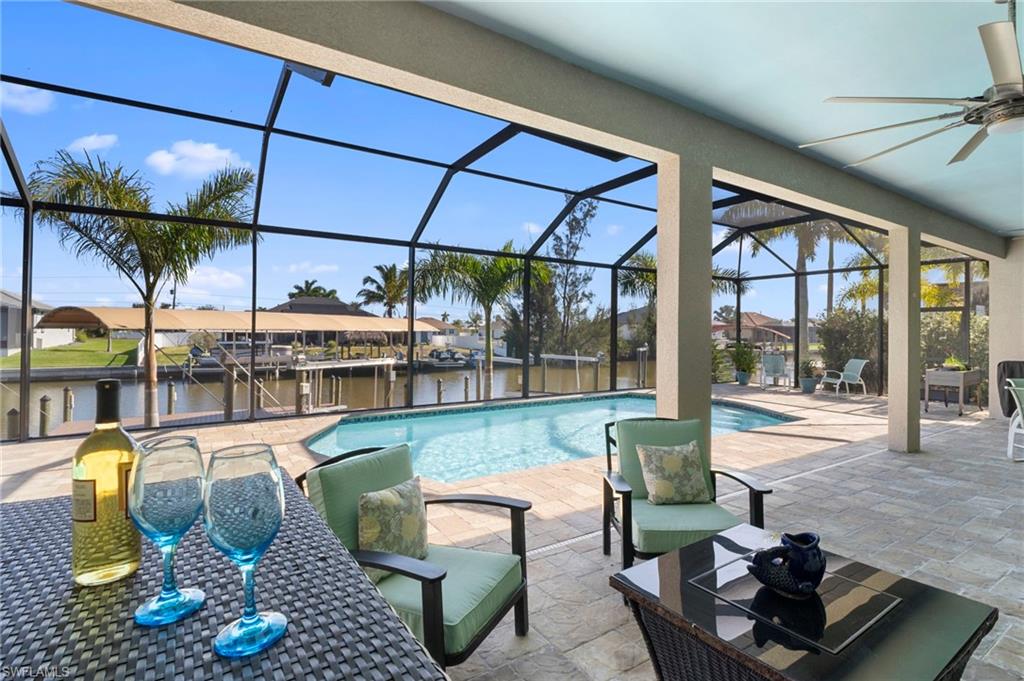 Outdoor pool with a lanai, a patio area, a sunroom, a water view, and a residential view