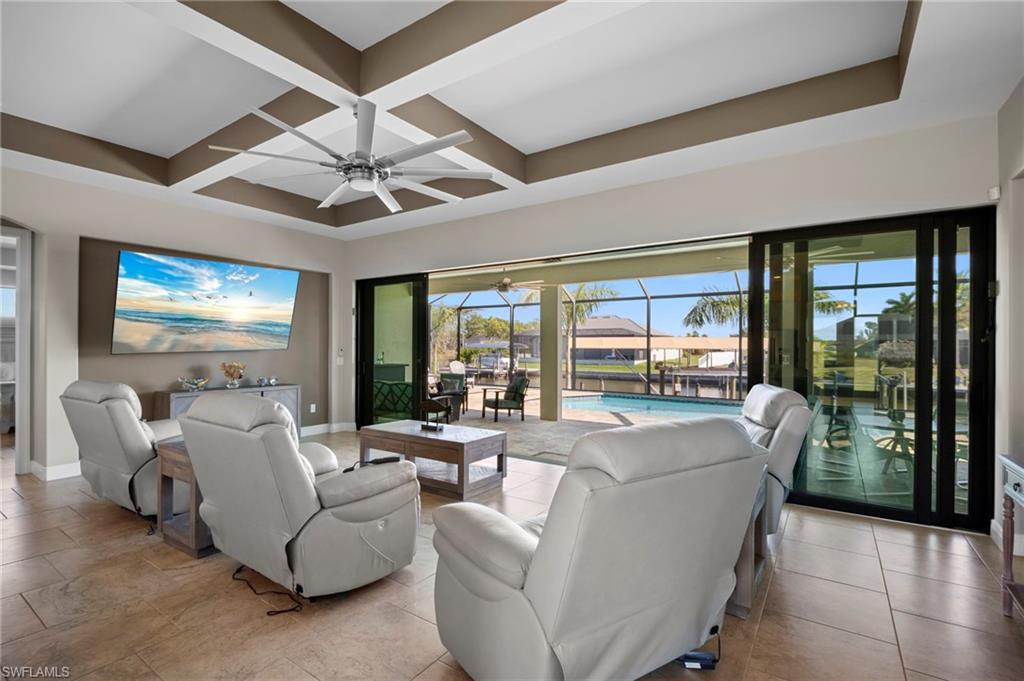 Living area with a sunroom, coffered ceiling, beam ceiling, and ceiling fan