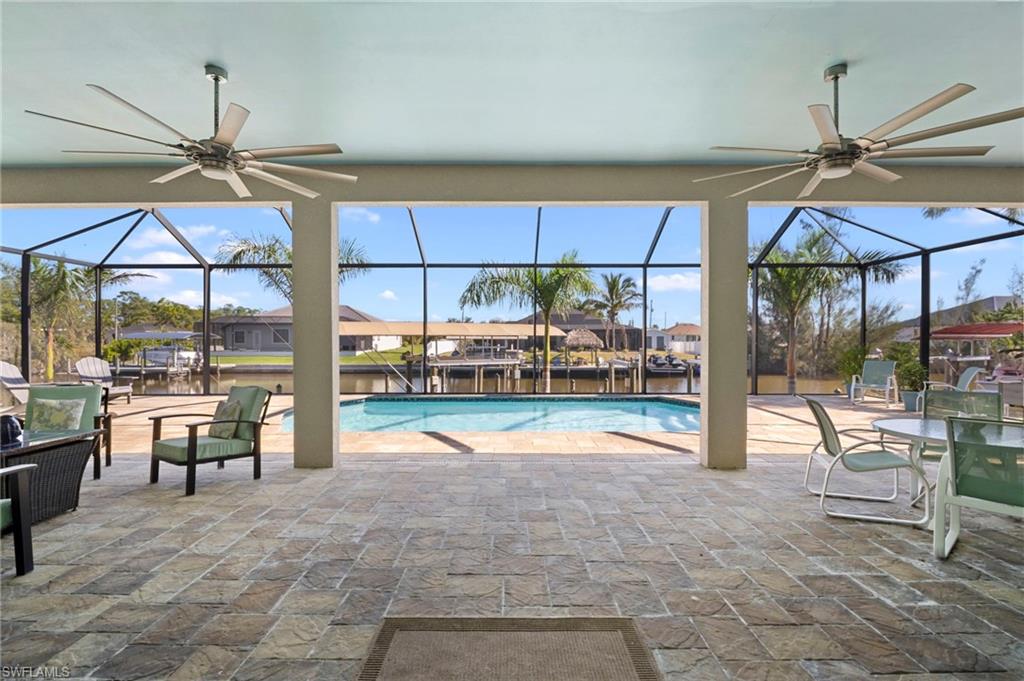 Swimming pool with a patio, a lanai, a sunroom, and a water view