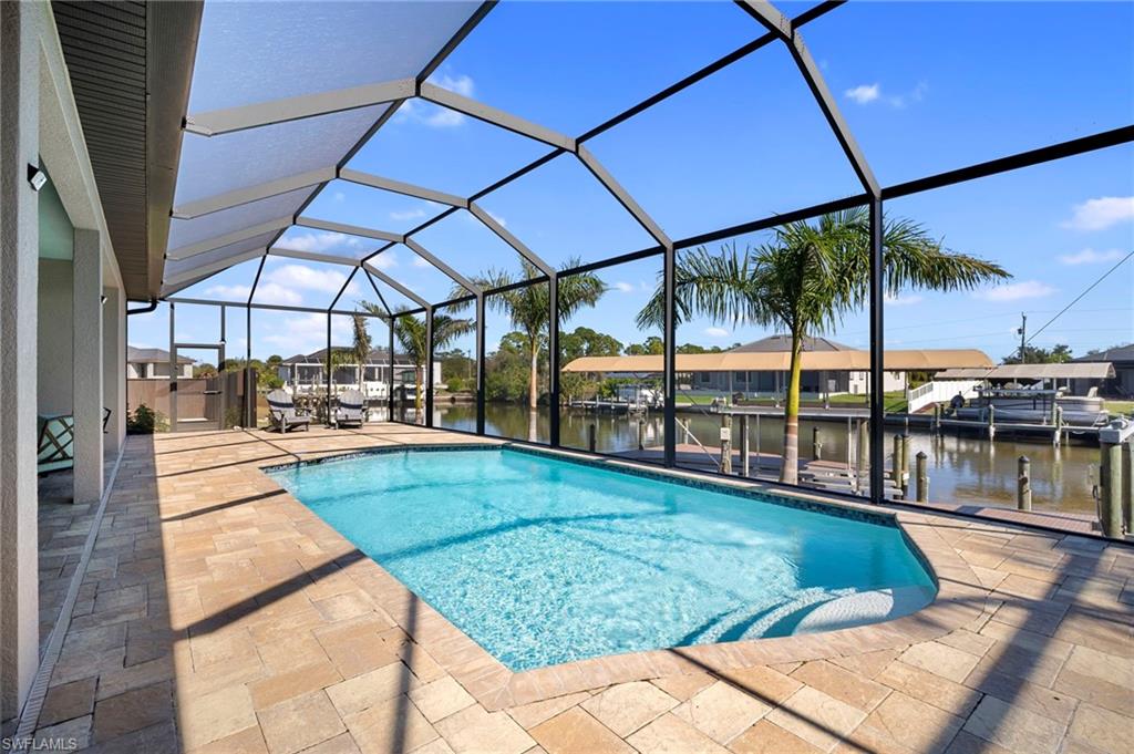 Outdoor pool with boat lift, a lanai, a boat dock, a patio, and a sunroom