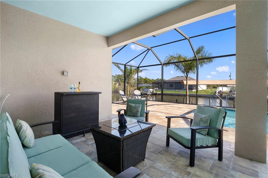 View of patio / terrace with a lanai, a sunroom, an outdoor pool, a water view, and an outdoor living space