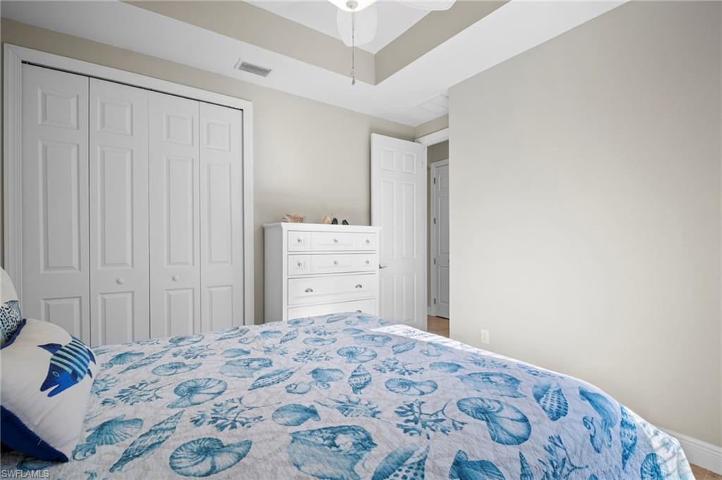 Bedroom featuring ceiling fan, a closet, and a raised ceiling