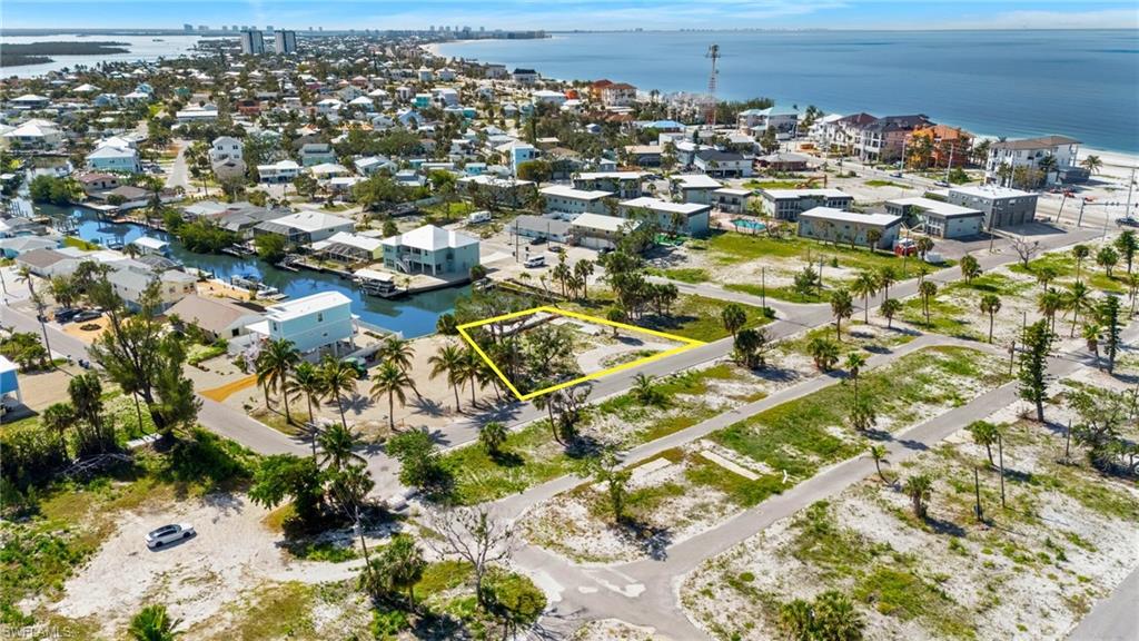 Aerial view of property and surrounding area featuring a large body of water and property boundaries highlighted  - Virtually Edited Image