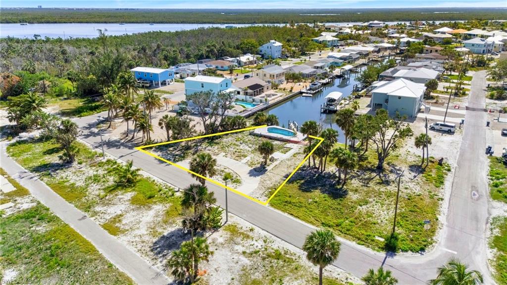 Aerial view of residential area featuring property parcel outlined and a large body of water  - Virtually Edited Image