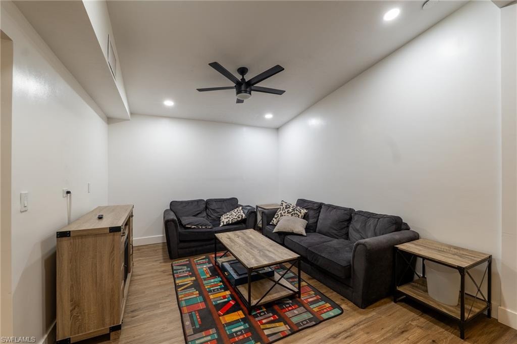 Living area with ceiling fan, light wood finished floors, and recessed lighting