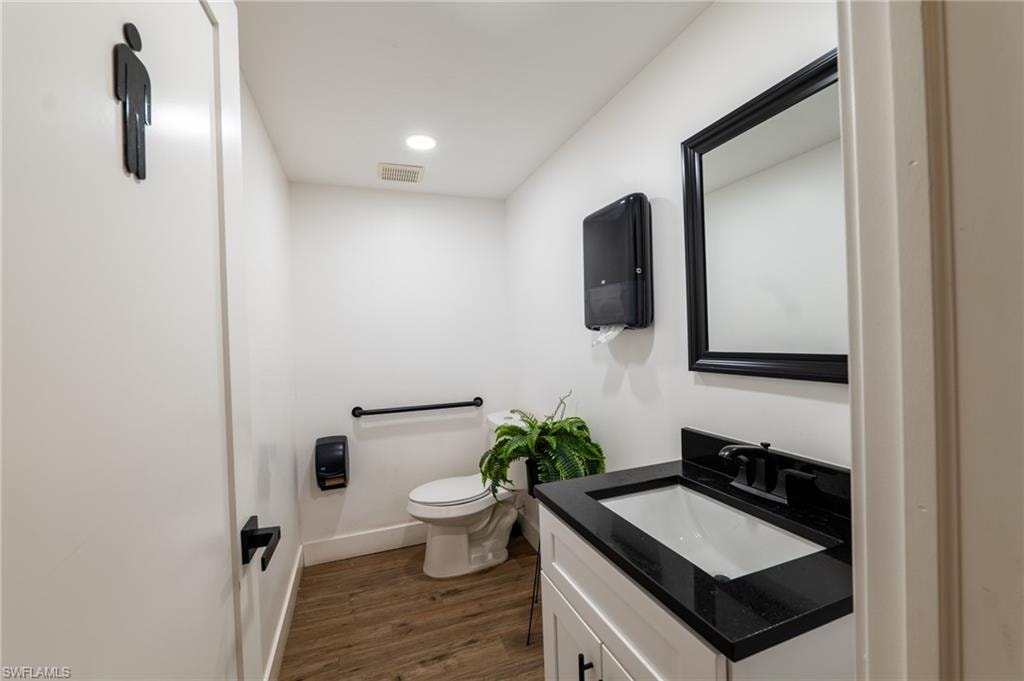 Bathroom featuring vanity, dark wood finished floors, and recessed lighting
