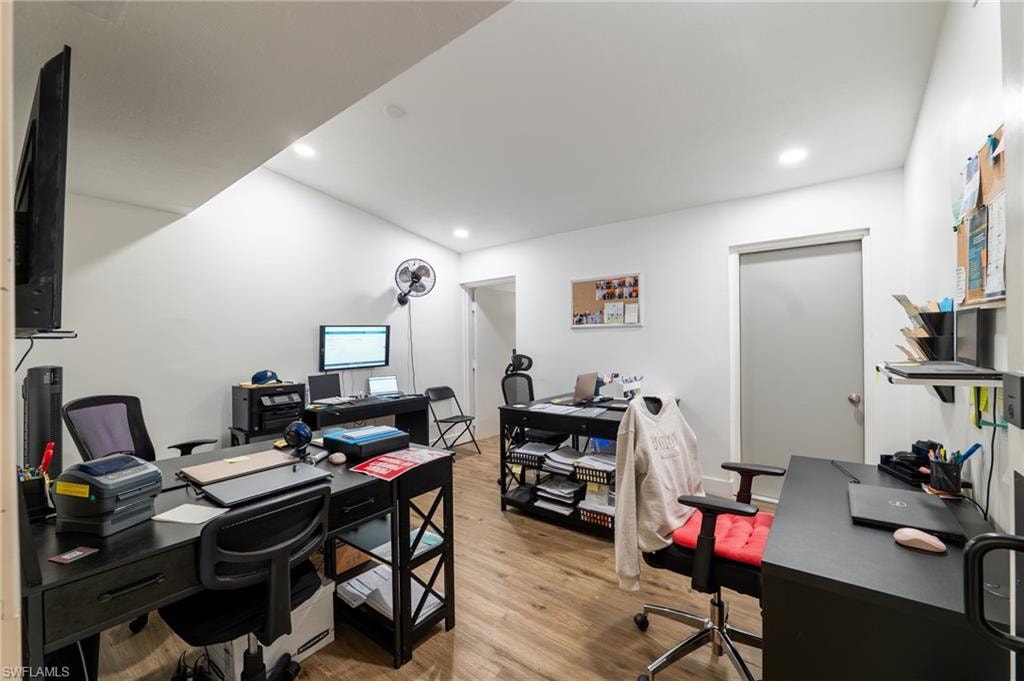 Office area featuring light wood-style floors and recessed lighting