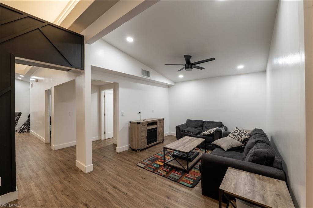 Living room with wood finished floors, recessed lighting, and a ceiling fan