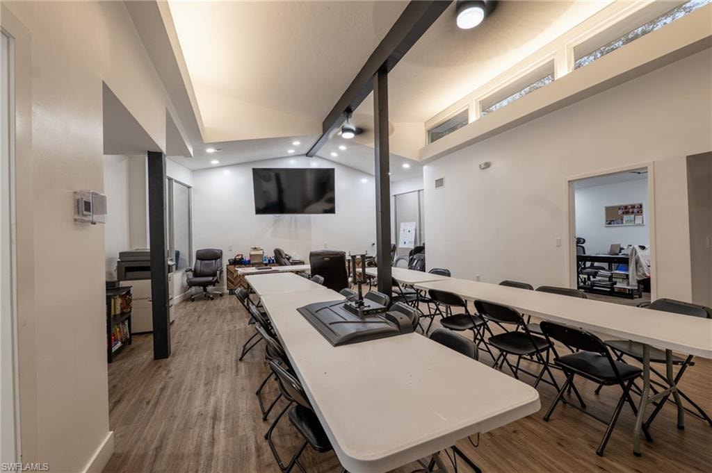 Dining area featuring lofted ceiling, an office area, and dark wood-style flooring
