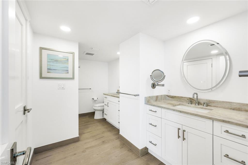 Bathroom featuring hardwood / wood-style floors, vanity, and toilet