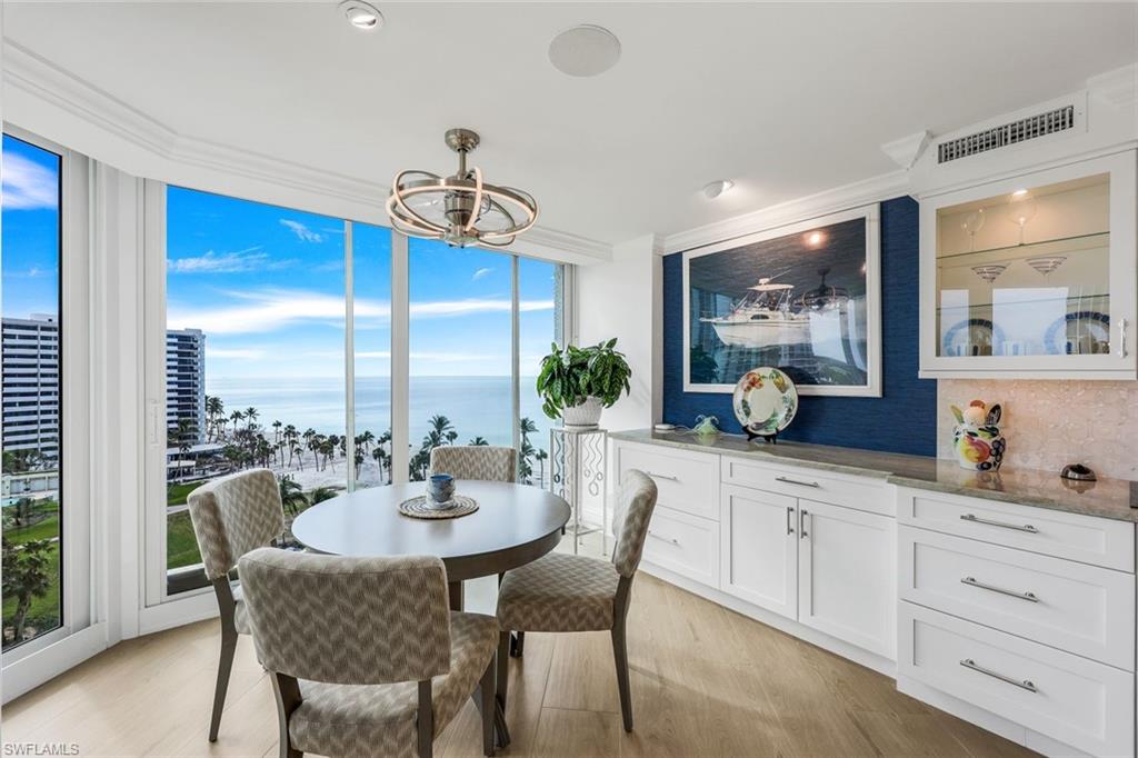 Dining area with a water view, light wood-type flooring, and ornamental molding